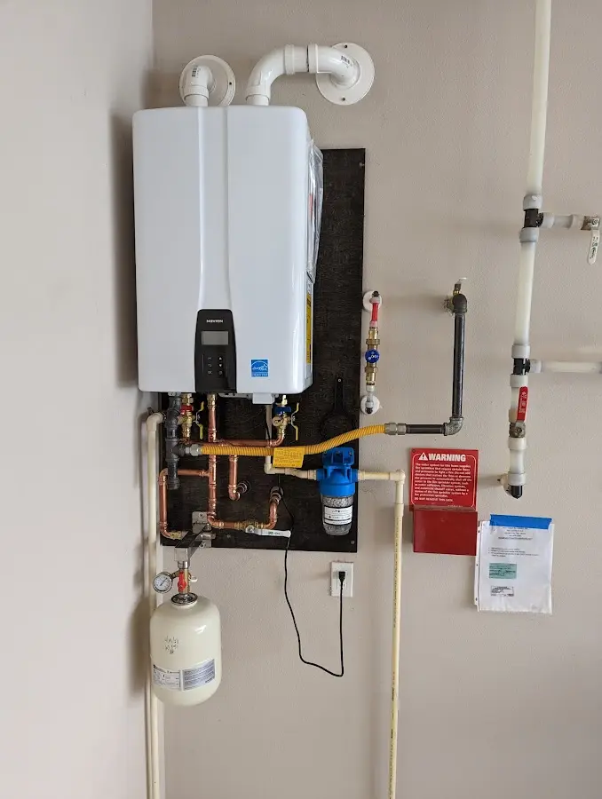 Professional plumber installing copper piping in a Le Ray home